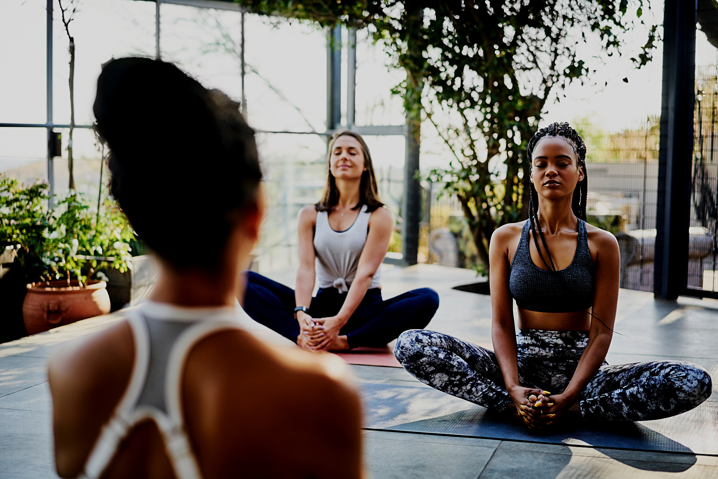 Women meditating with instructor during yoga class